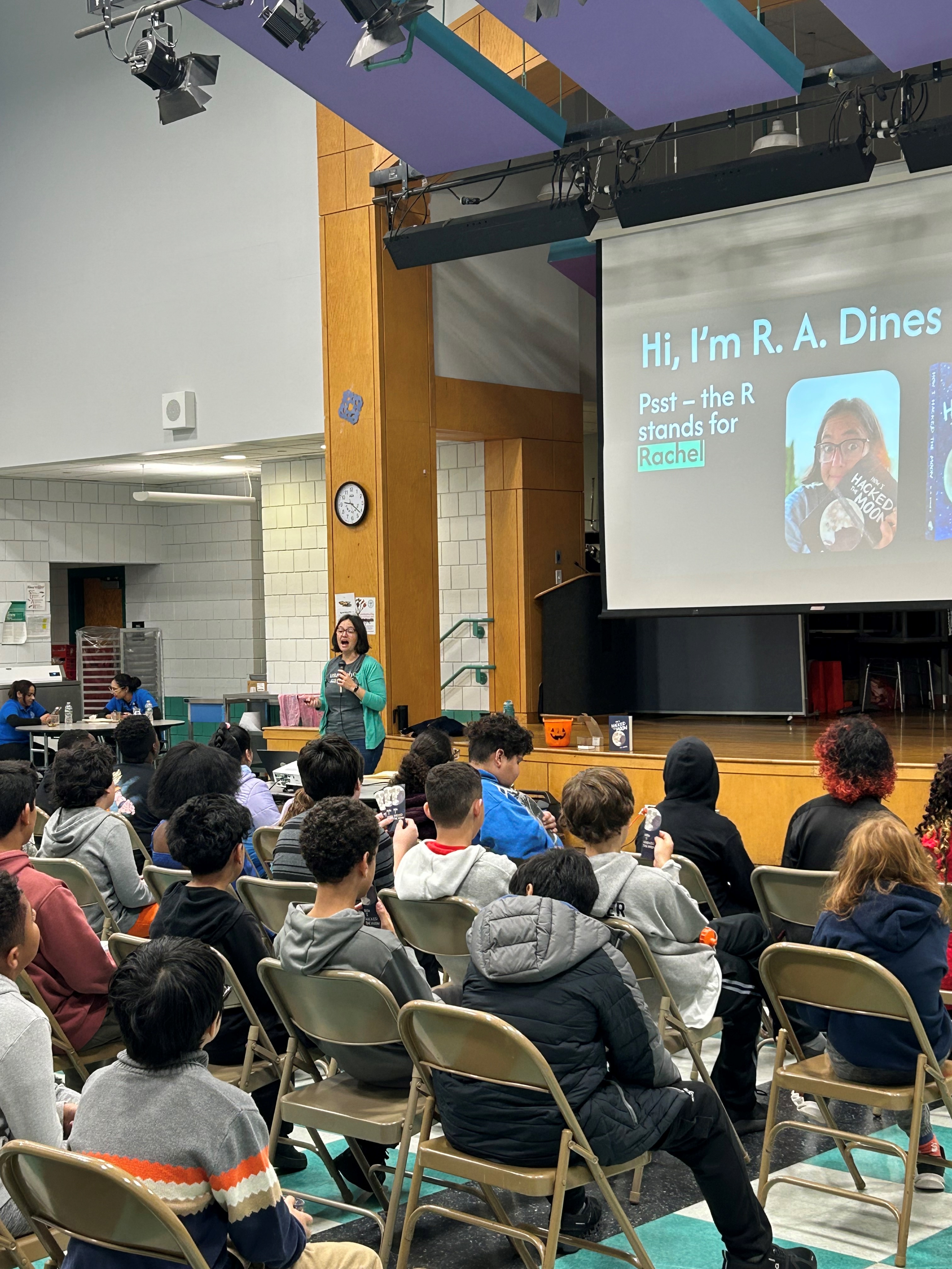 R. A. Dines presenting to students in a school gymnasium